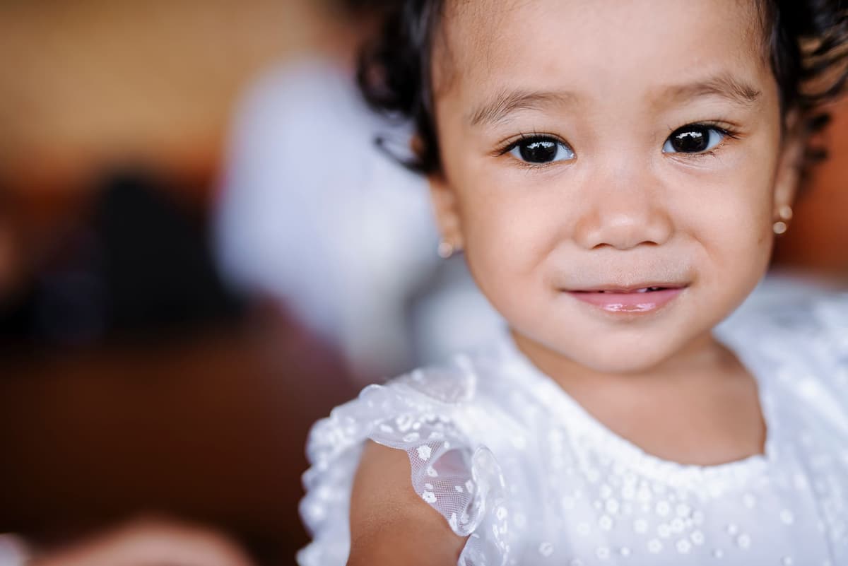 a toddler with a mud-smeared face smiling widely
