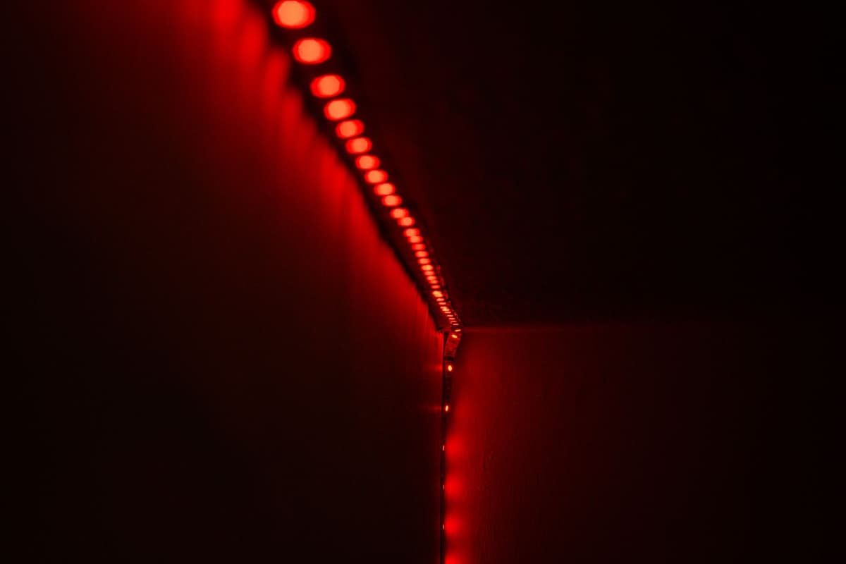 a single glowing red standby light in a dark room