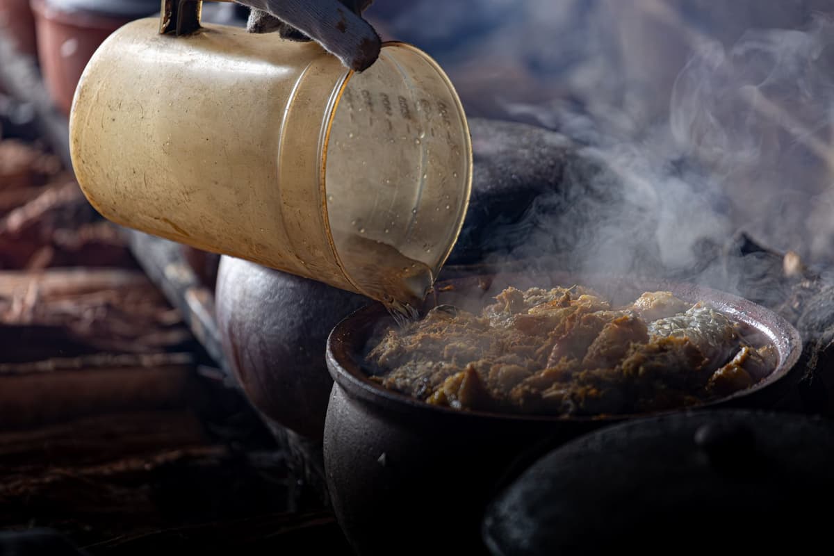 a scientist holding a high-tech sensor over a dusty clay pot