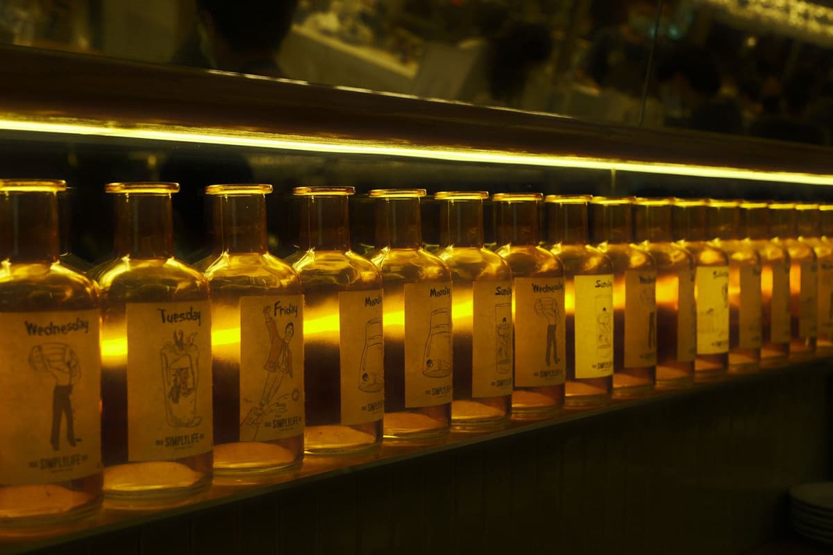 a row of identical glass jars filled with glowing blue liquid on a supermarket shelf