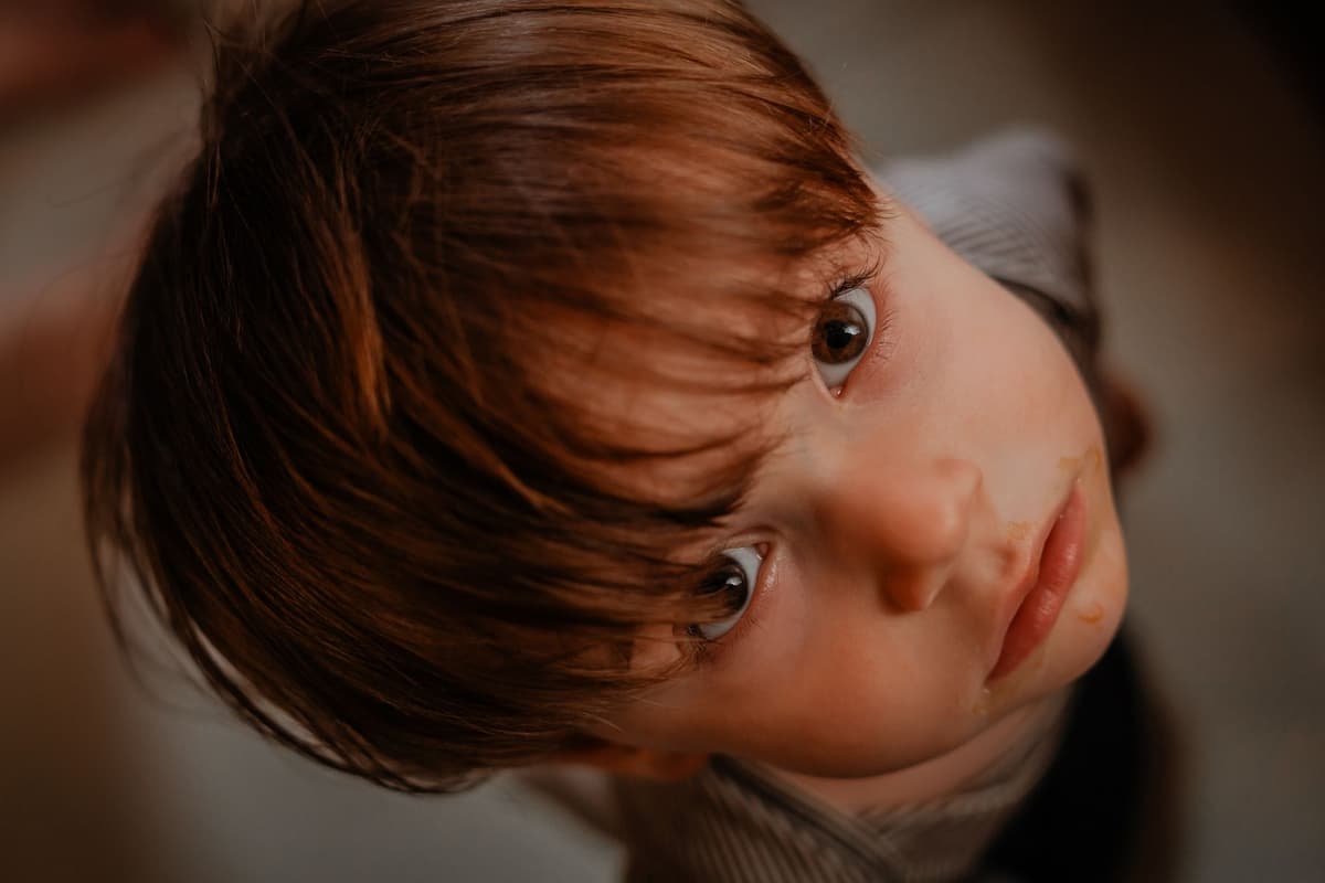 a child staring intensely at a single blade of grass