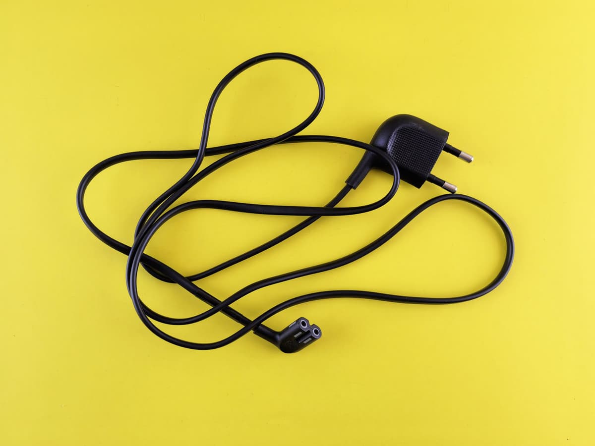 tangled black cables overflowing from a dusty shoebox