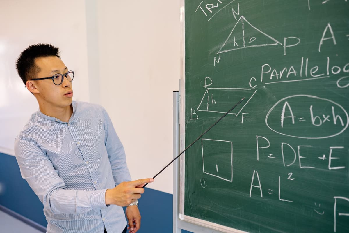 a confused professor staring at a chalkboard covered in emojis