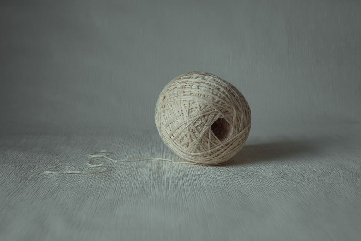 a tangled ball of colorful yarn with some loose threads falling out