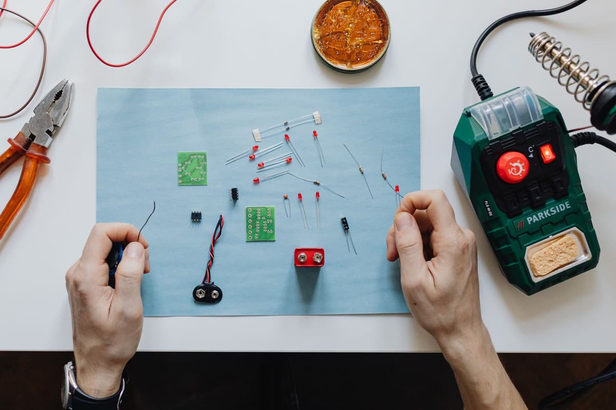 close up soldering wires to green circuit board