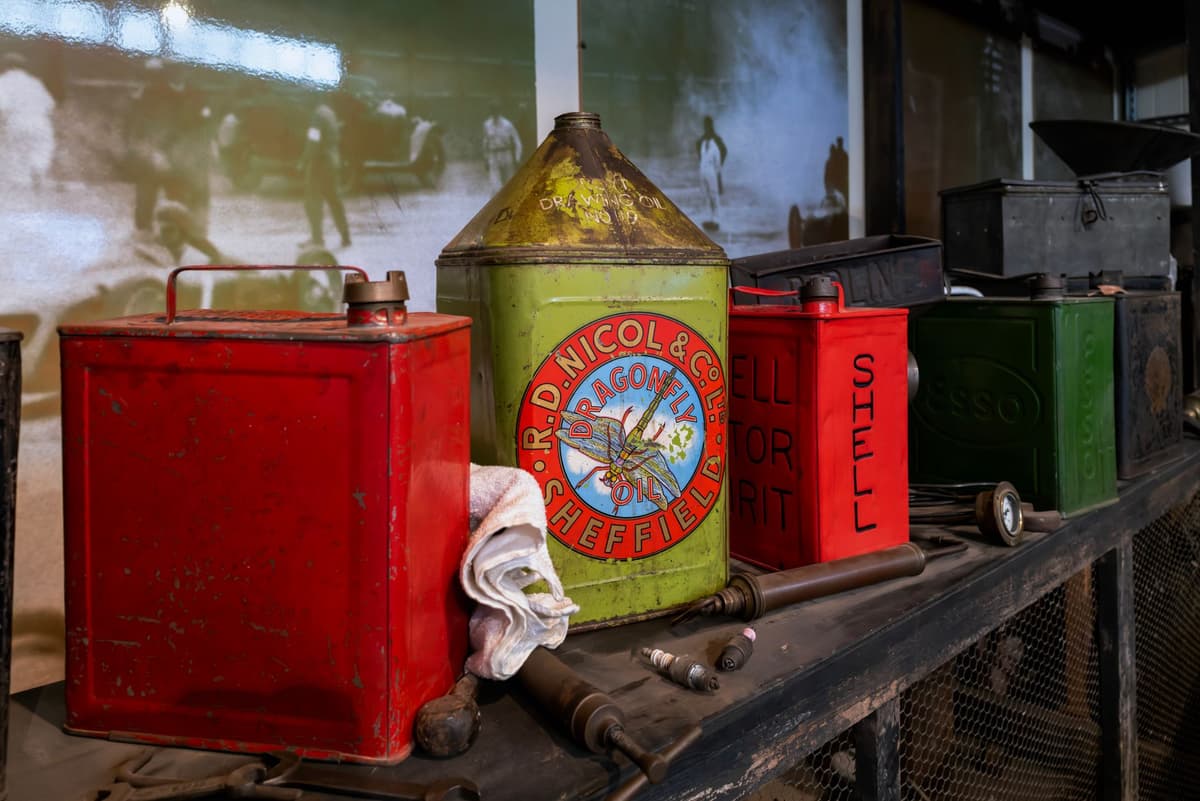 a mountain of motor oil jugs stacked in a dusty garage corner