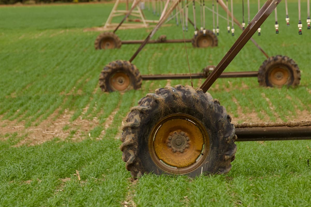 a rusted 1970s industrial irrigation pump in a lush green field