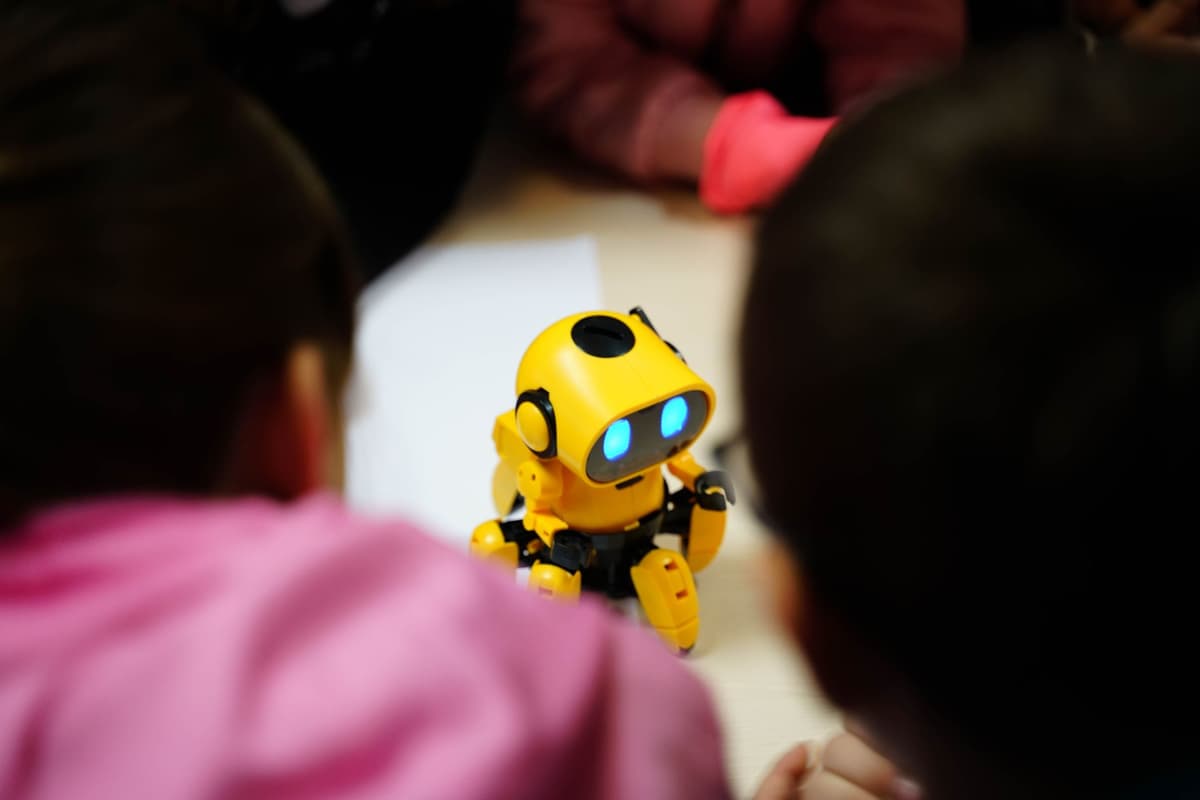 a single shiny apple sitting on a table surrounded by several different colorful robot toys