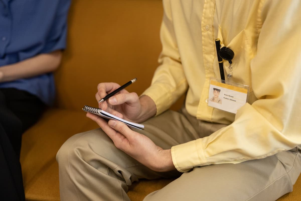 a nervous hand holding a plastic ID badge near a glowing red scanner