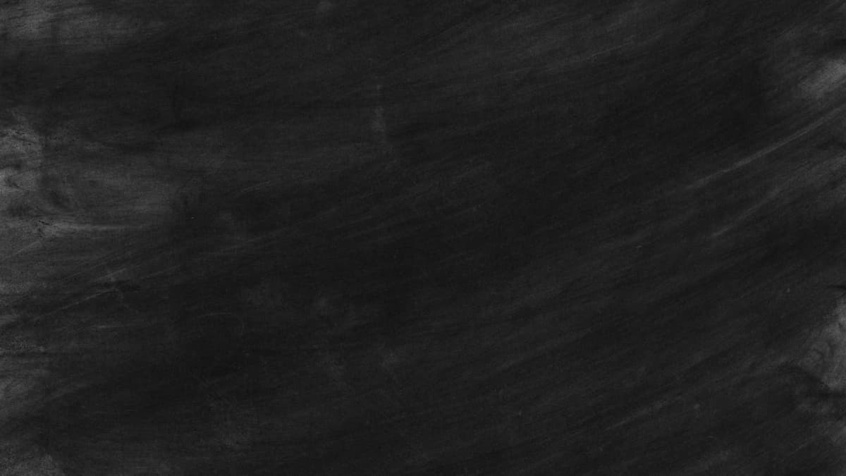 a dusty chalkboard covered in erased, illegible equations