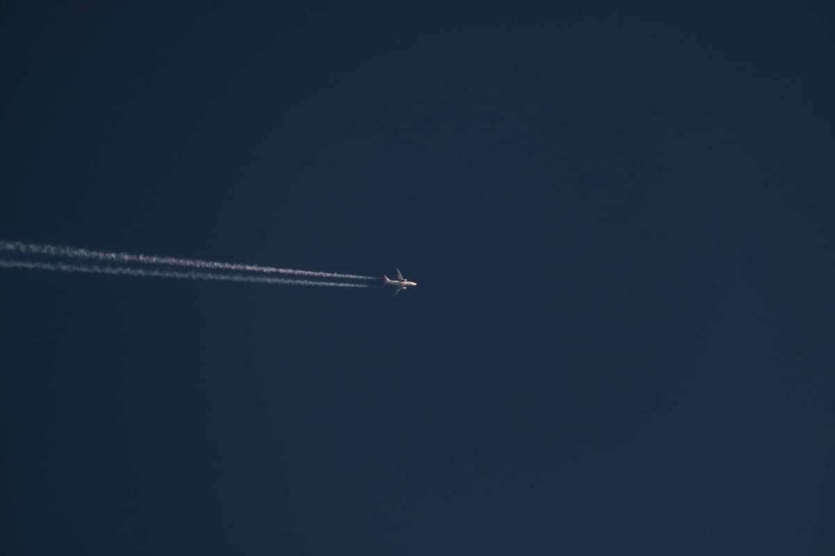 a single white jet contrail curving wildly