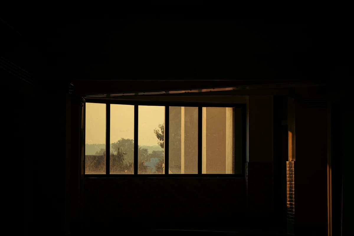 a dimly lit room with a single monitor displaying a plane wing at sunset