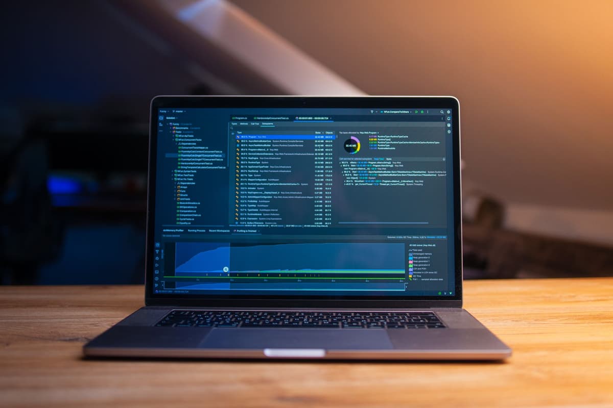 a dusty vintage laptop on a wooden desk showing a glowing terminal window