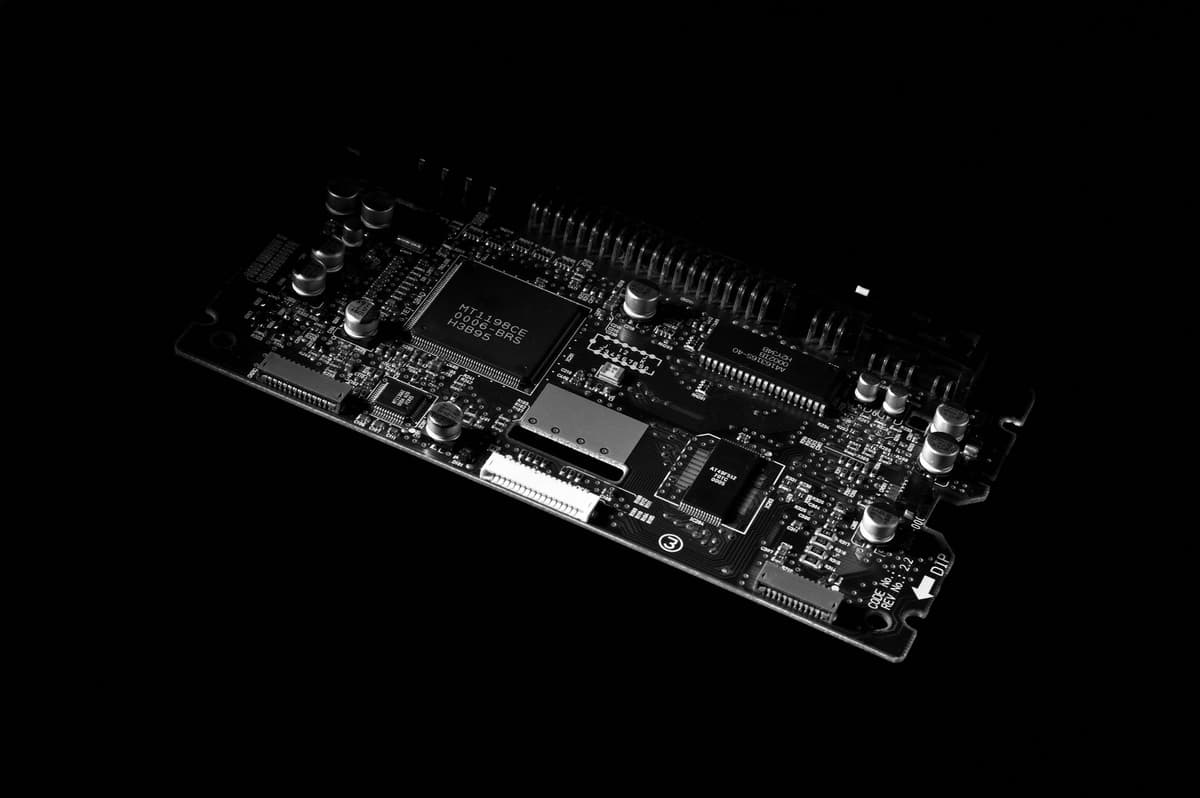 a single glowing green circuit board on a dark glass table