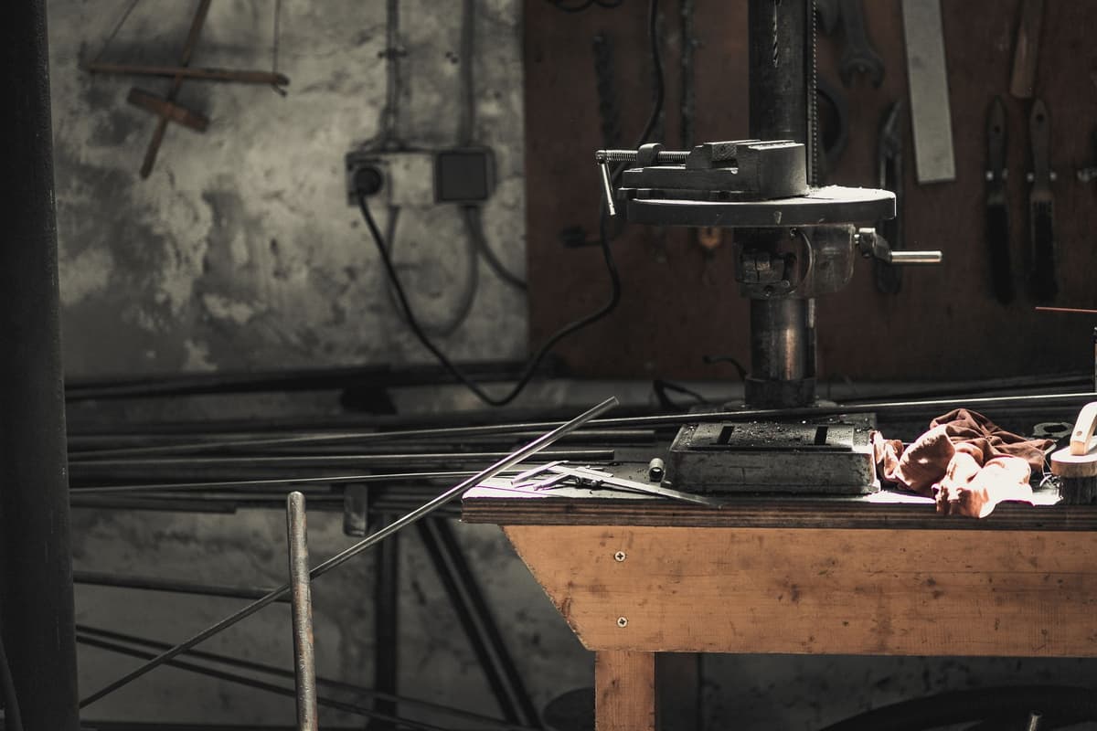 a single metallic cylinder reflecting light on a dark workbench