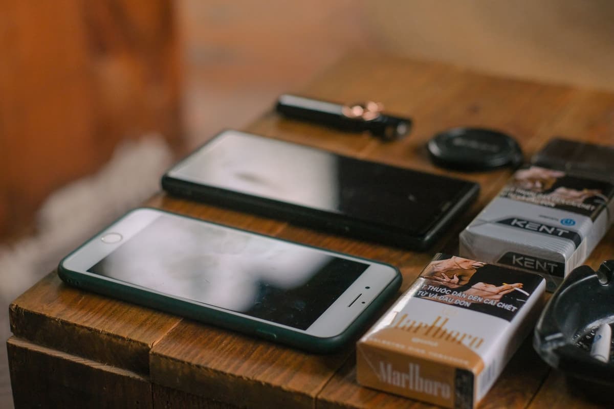 a dusty silver flip phone on a wooden table