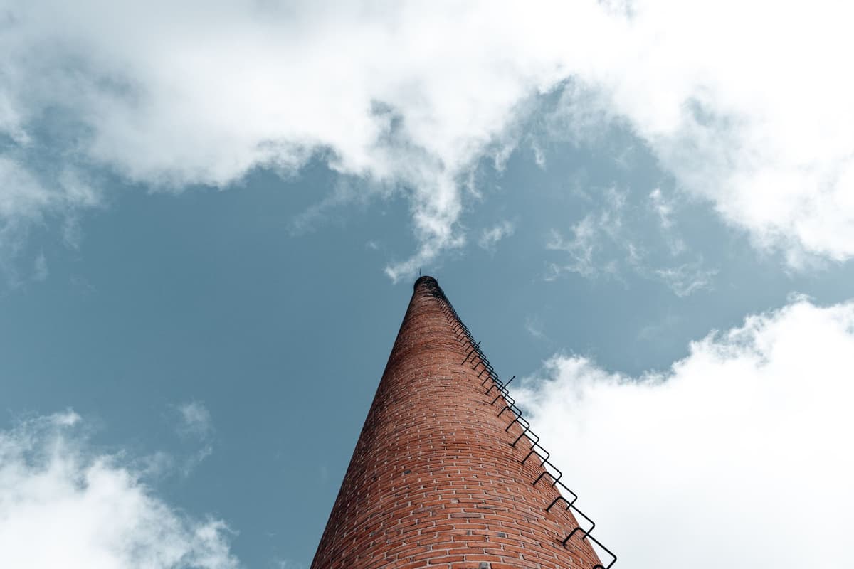 a mud-covered brick chimney standing alone in a dry lakebed