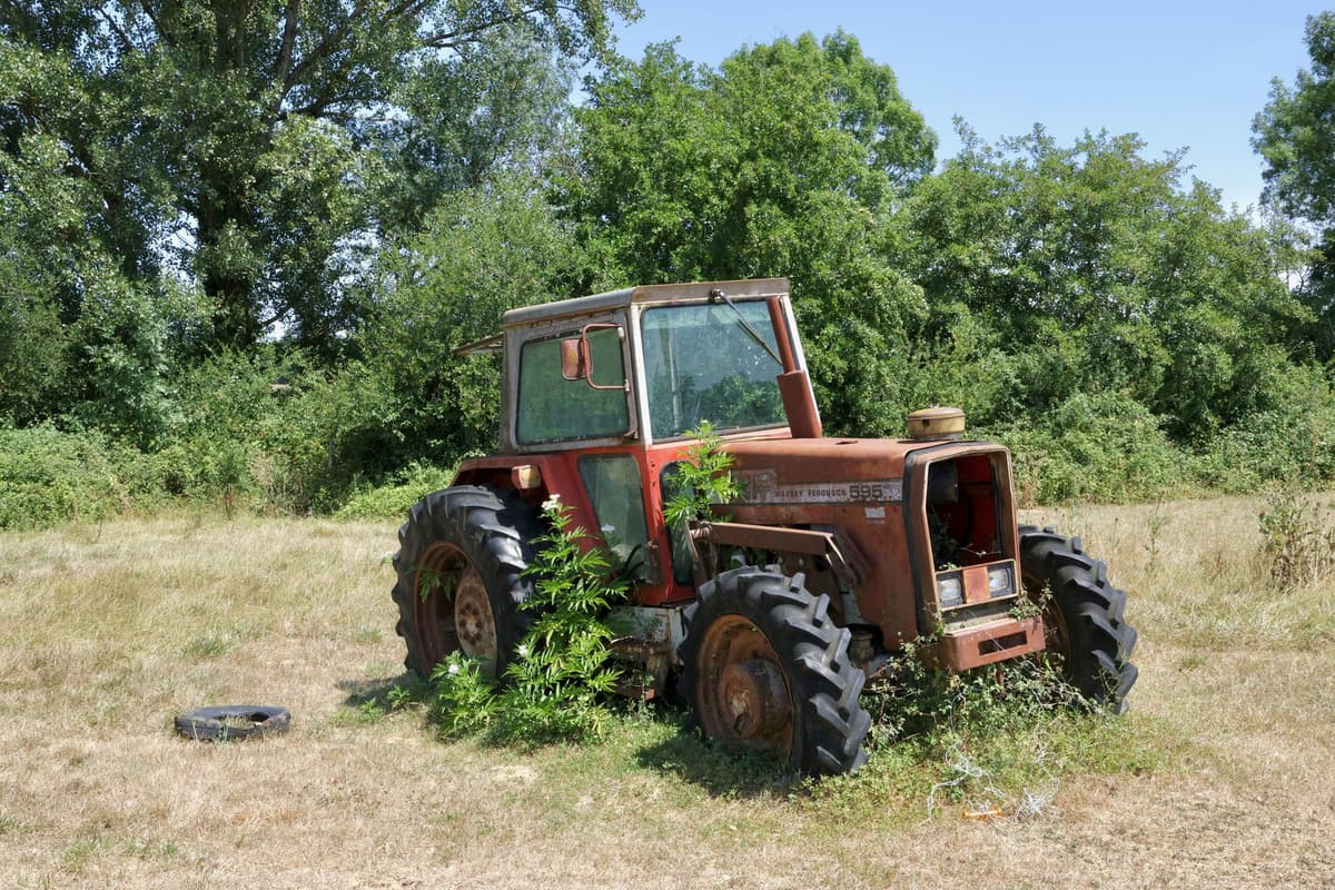 a dusty tablet computer resting on a rusted tractor hood