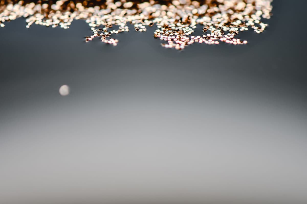 a single penny sitting next to a mountain of microscopic plastic gears