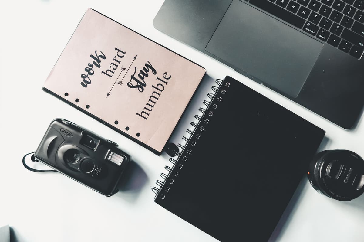 vintage mechanical camera beside open modern laptop