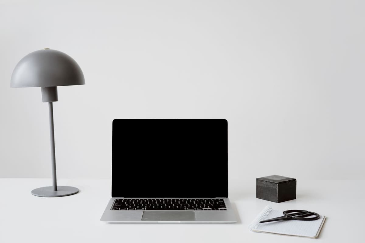 A single, perfectly placed, minimalist desk lamp illuminating a pristine, empty desk