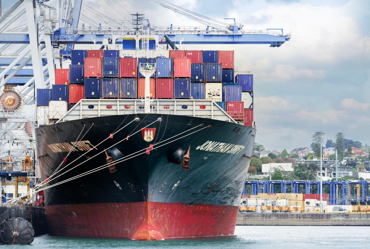 a stack of colorful shipping containers being moved by a crane