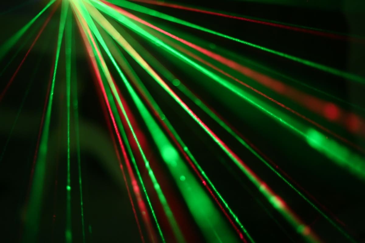 a single green sprout under a glowing blue laser light