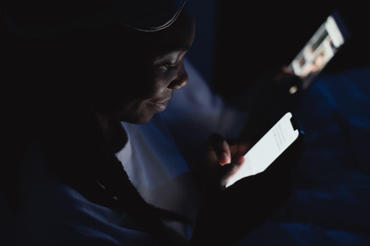 glowing smartphone screen illuminating a face in total darkness