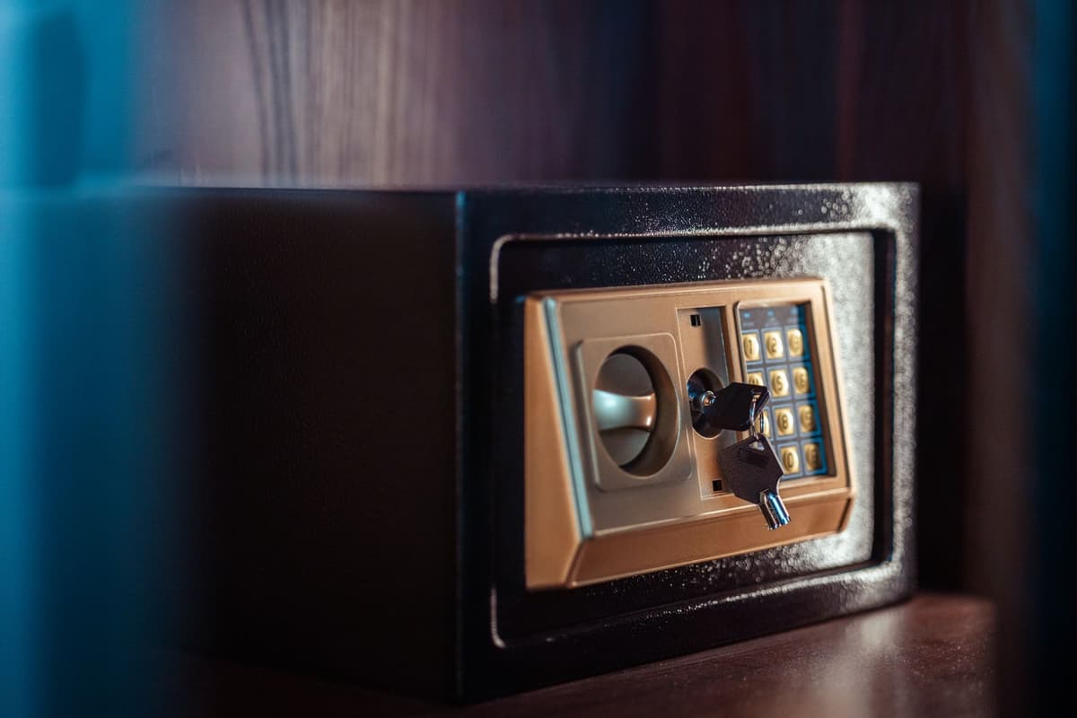 a single silver key sitting inside a heavy glass safe