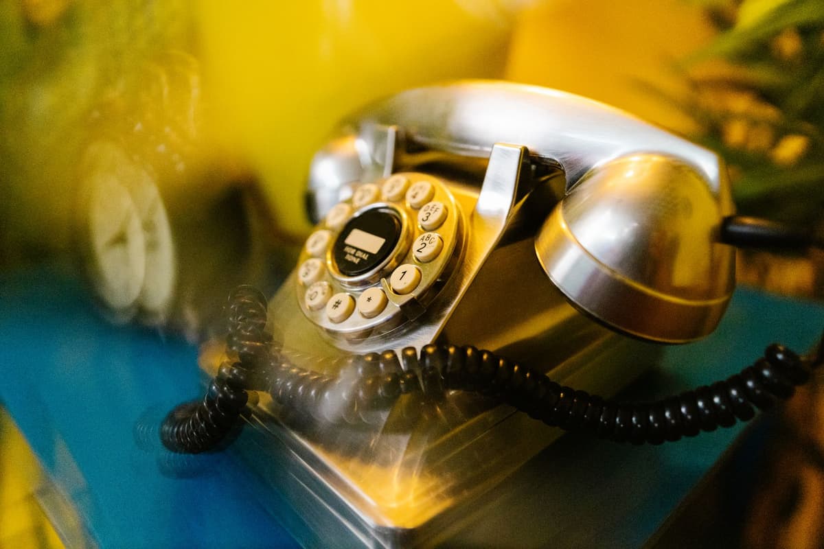 a dusty, vintage rotary phone sitting next to a sleek modern smartphone