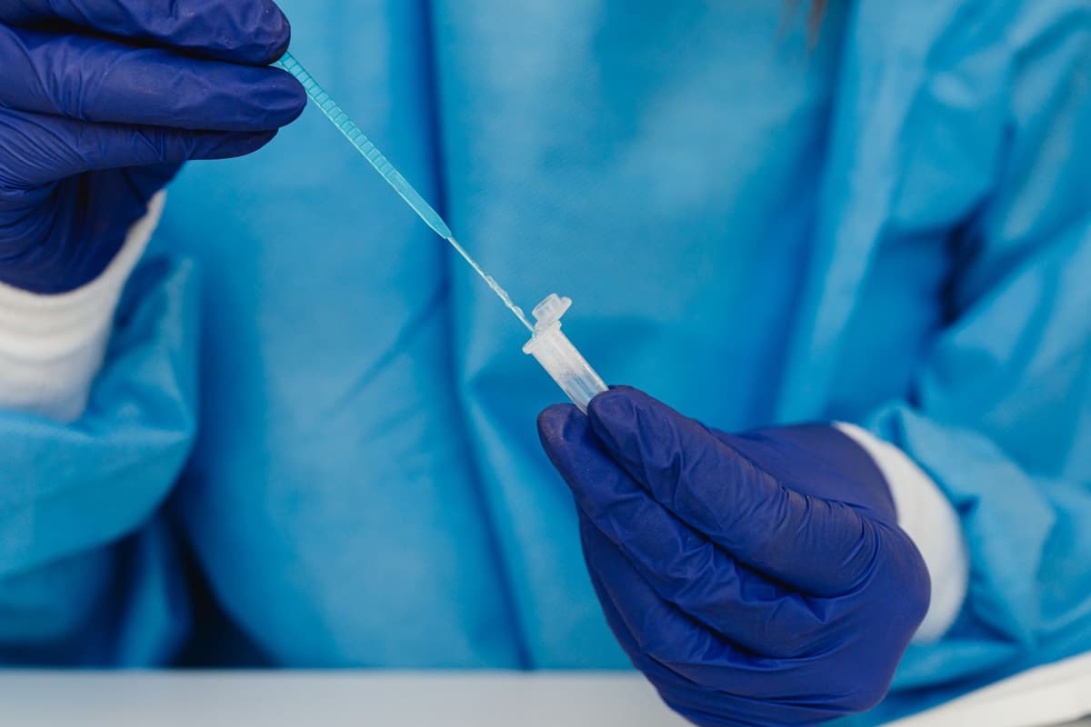 gloved hand using a micro-pipette in a clean lab