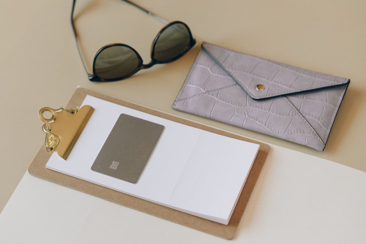 a single white credit card balanced on a minimalist stone pedestal