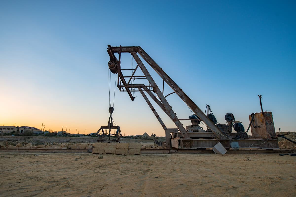 rusty metal backhoe sitting in deep lunar dust