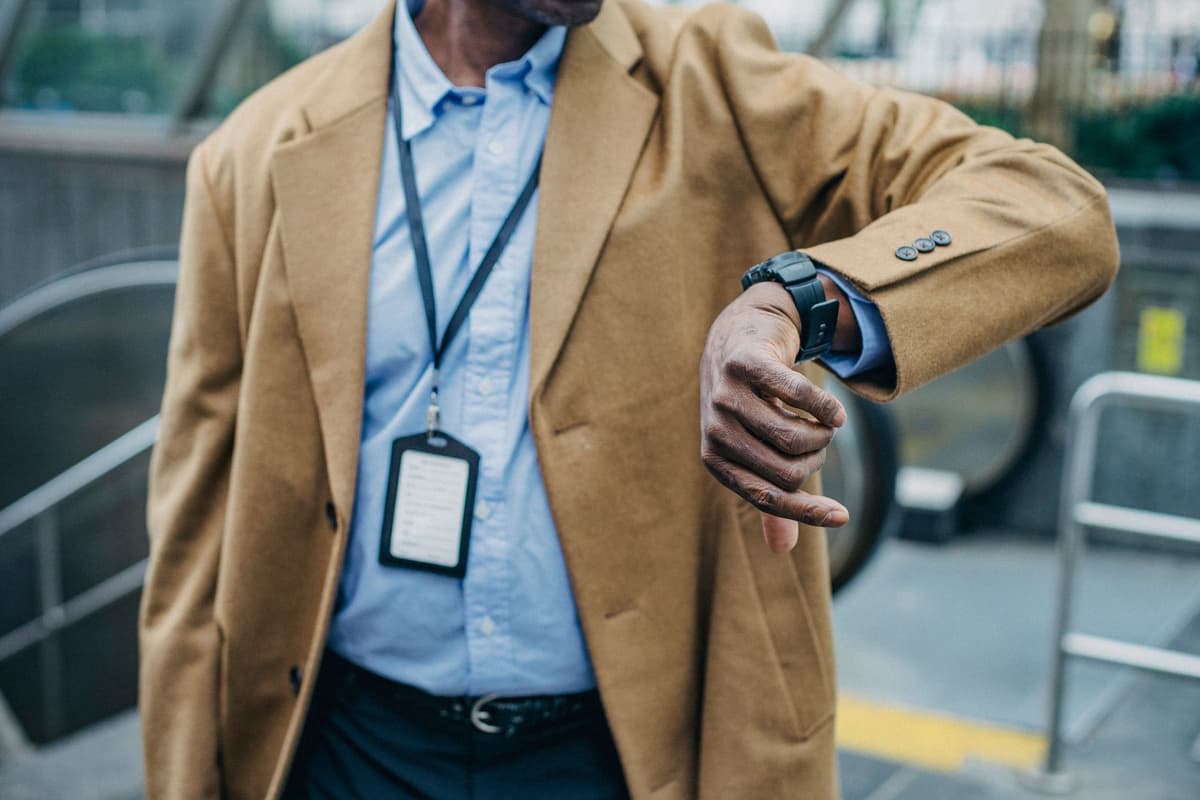 a man checking his watch while standing on an escalator