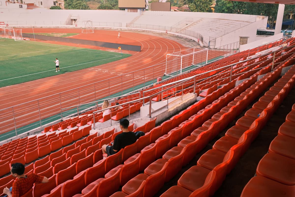 empty athletic track lanes stretching toward empty stadium stands