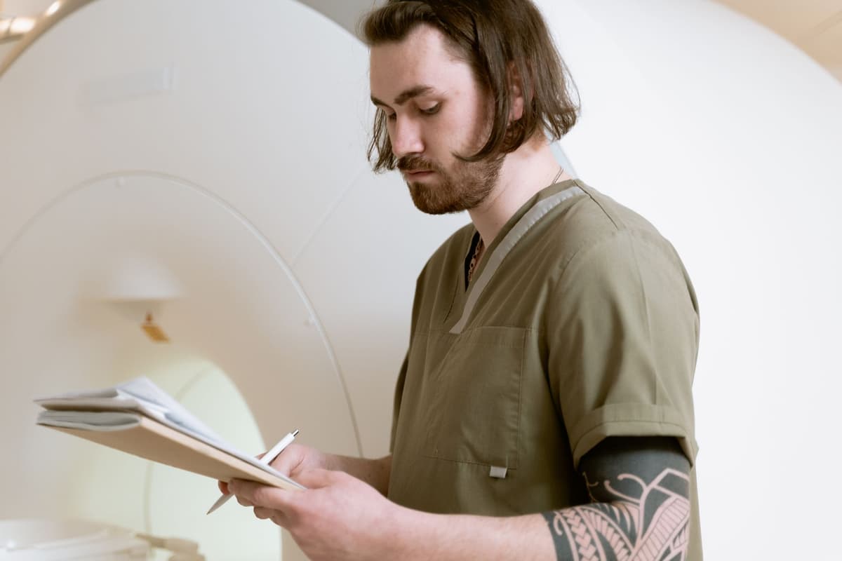 a doctor looking thoughtfully at a complex medical scan on a screen
