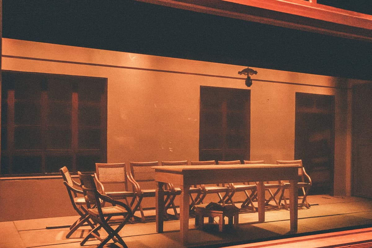 a single wooden chair in a dark empty room