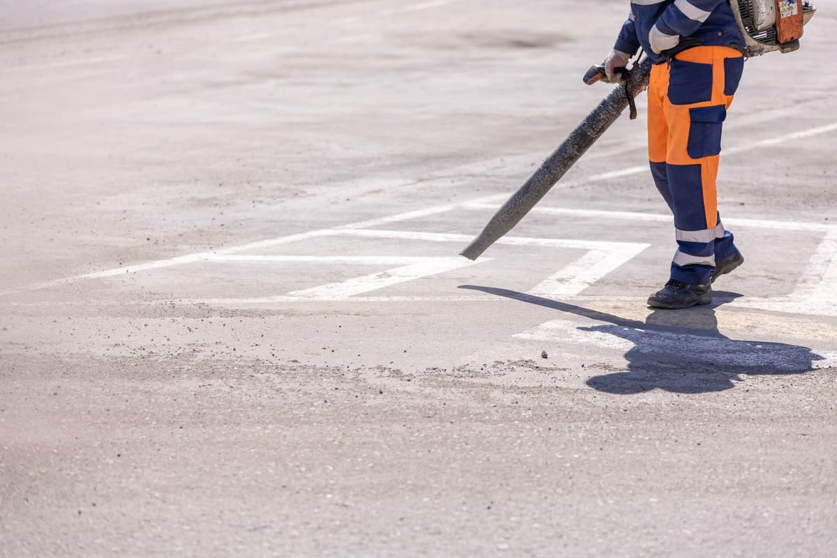 a man using a leaf blower on a single pebble
