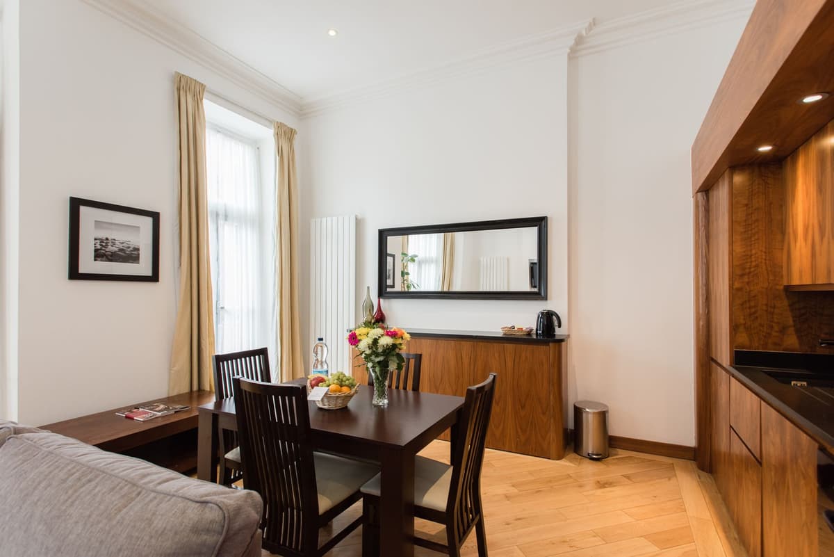 a Victorian dining room with dark wood furniture and heavy curtains