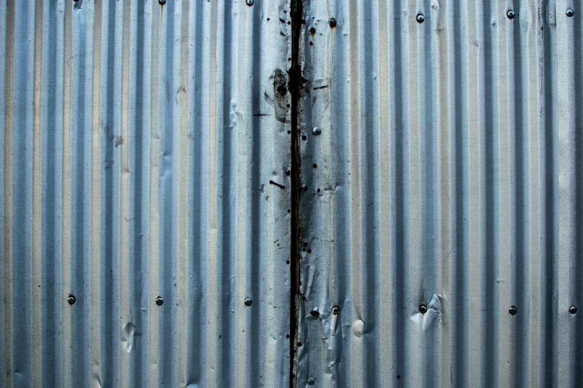 a rusty corrugated metal hangar in shimmering desert heat