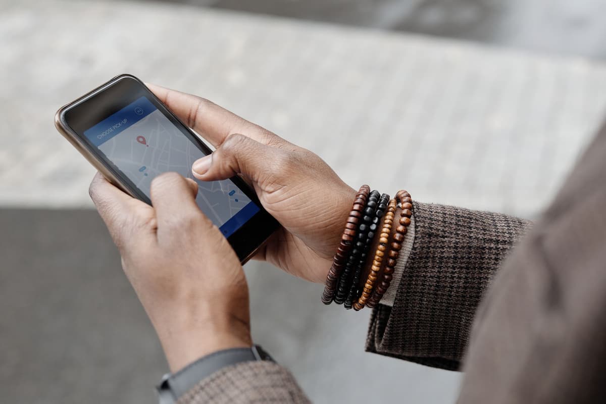 a person holding a smartphone over a cobblestone street