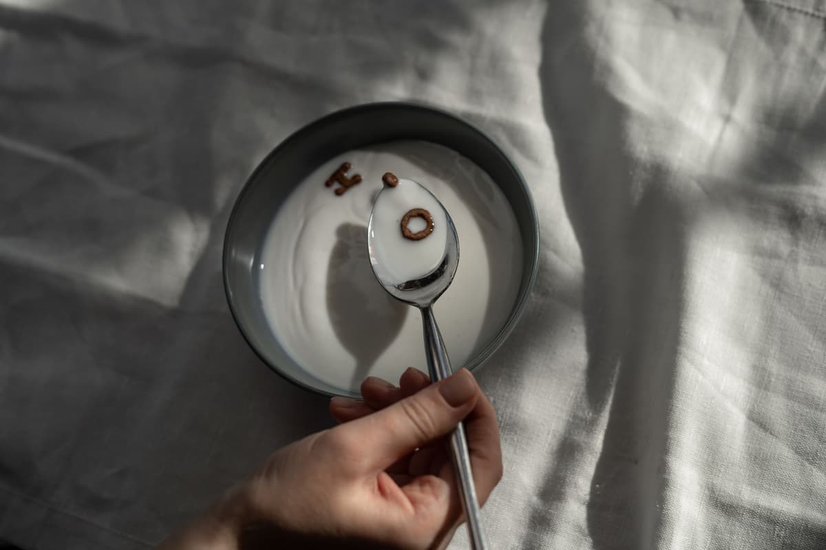 a single gold key floating inside a messy bowl of alphabet soup