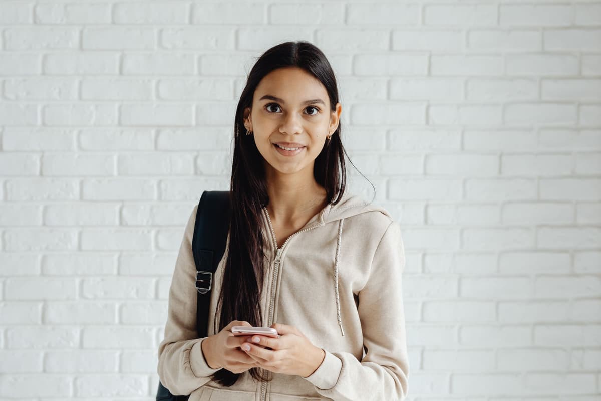person holding smartphone looking at front-facing camera