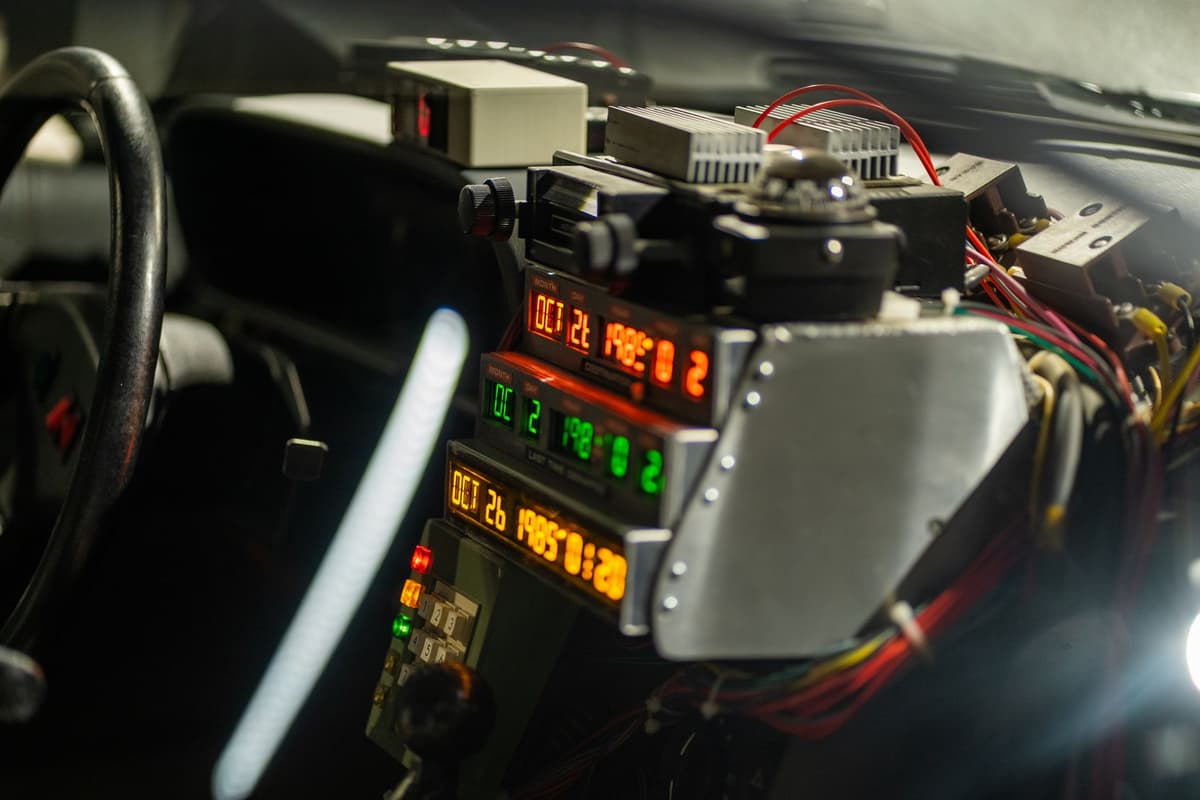 a tangled nest of multicolored wires behind a dashboard