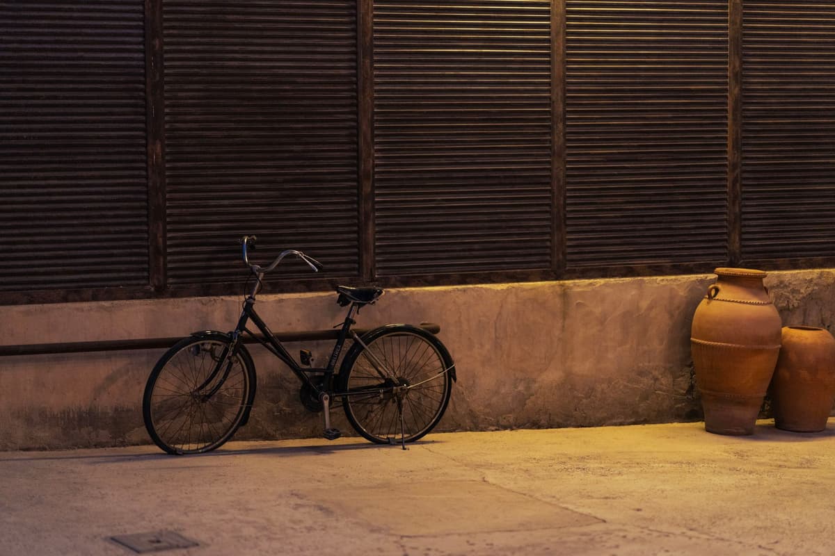 a vintage high-wheeler bicycle under a single spotlight