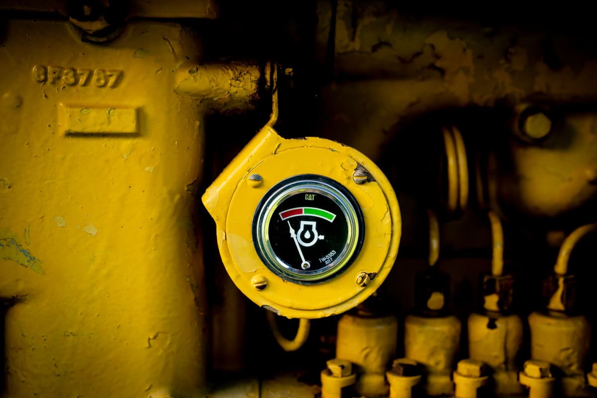 a dusty green tractor engine with a small metal box bolted to the side