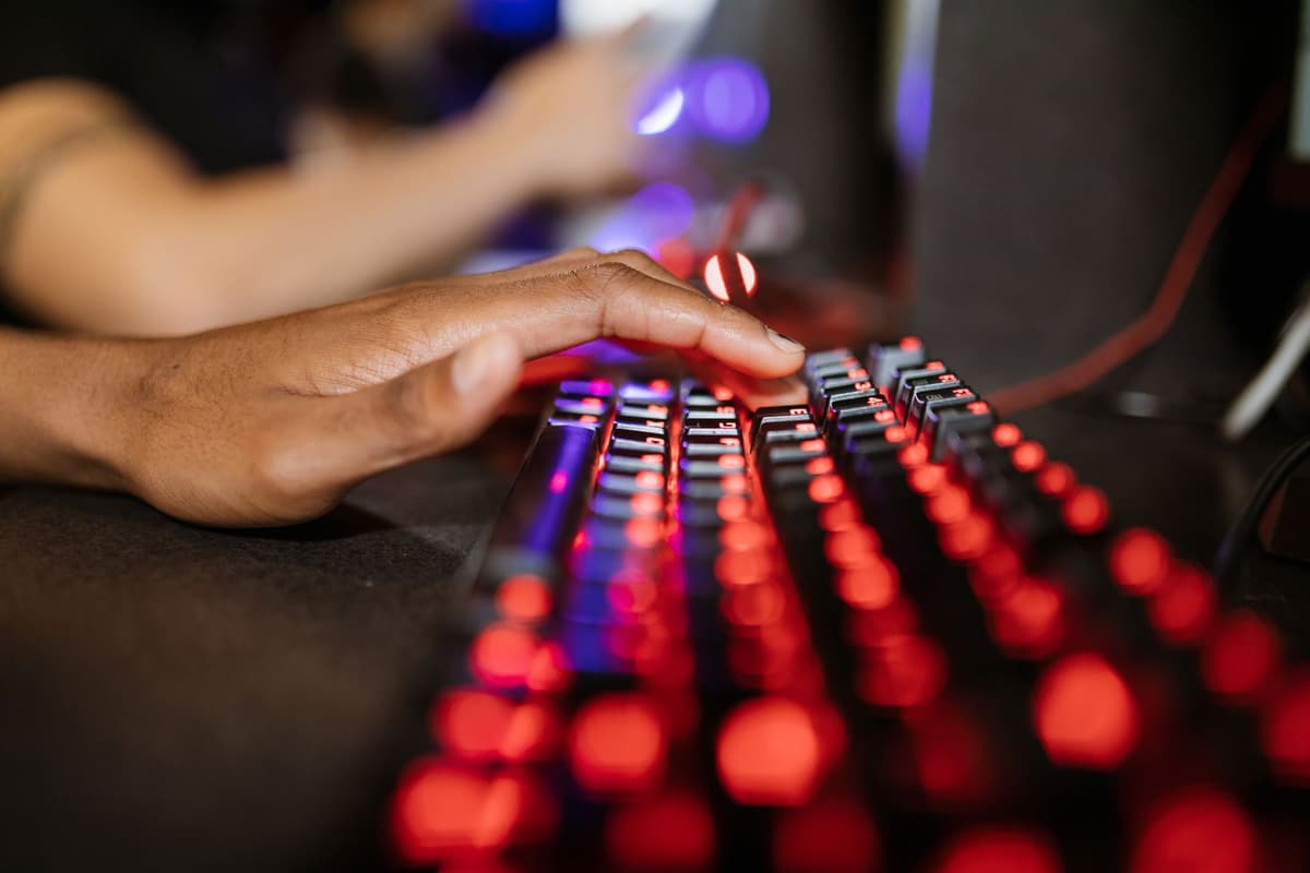 close up of worn illuminated gaming keyboard in dark room