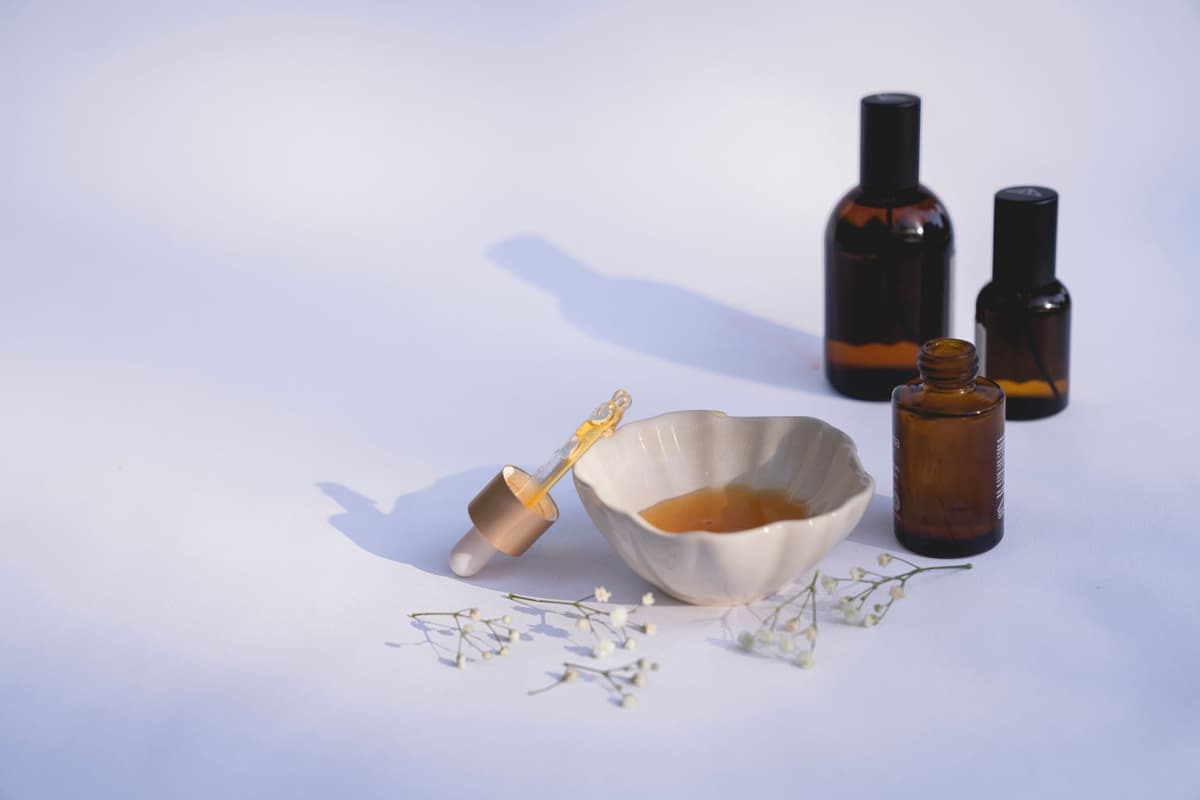 row of identical luxury skincare dropper bottles on marble