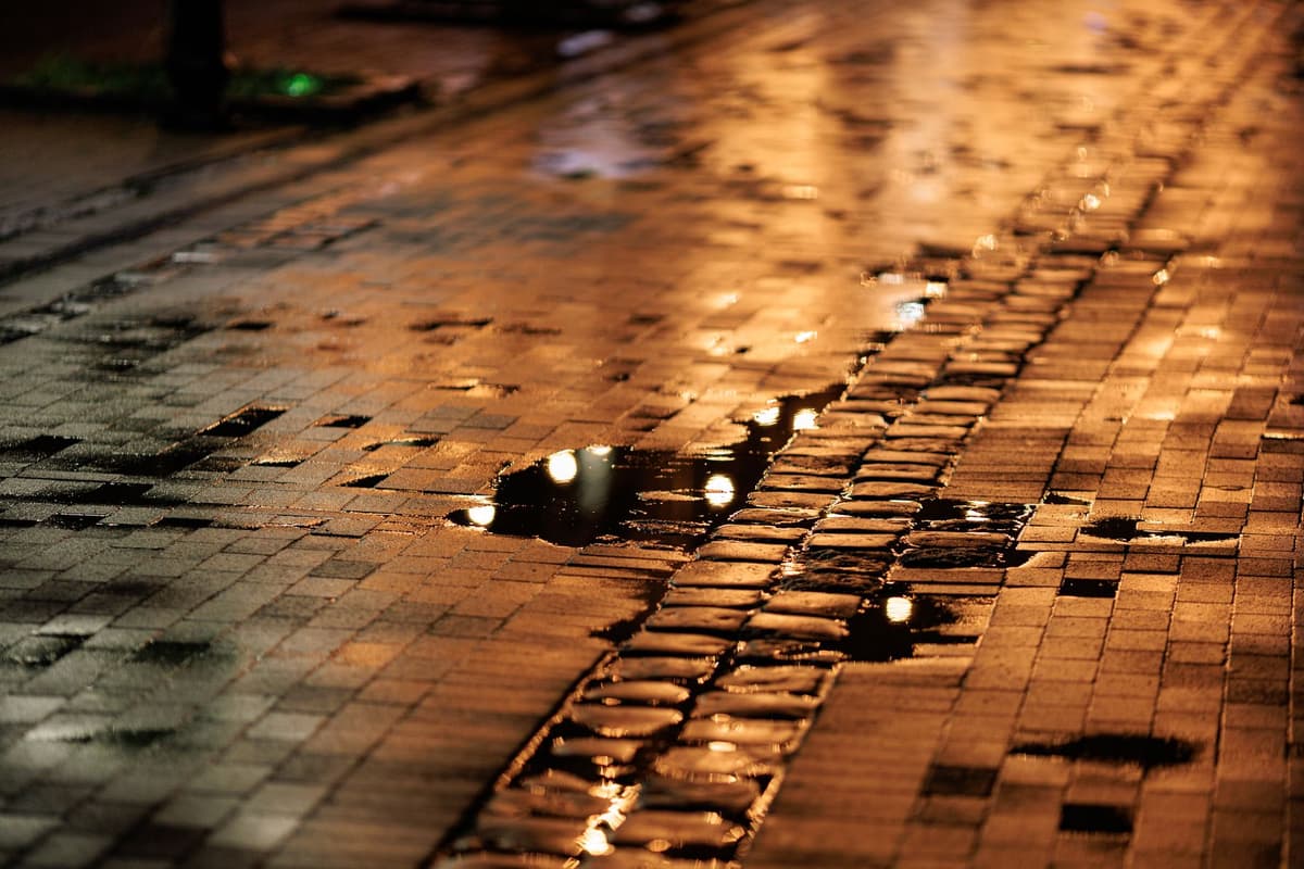 a single bright light reflected in a dark puddle