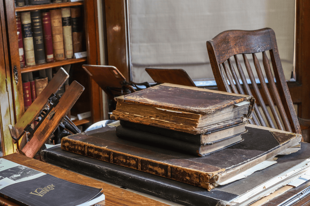 a dusty library with books falling open on the floor